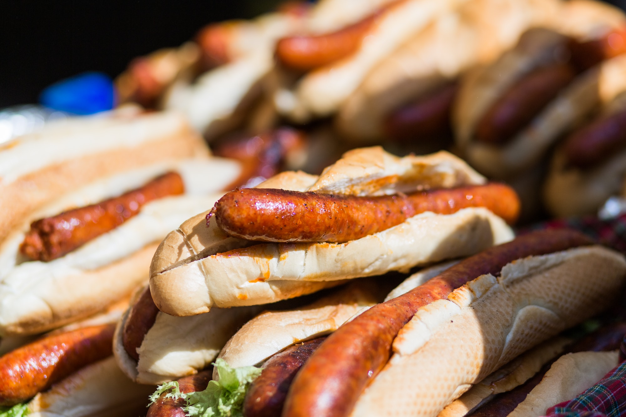Hot dog, hot dogs are in a bunch, a lot of hot dogs, a showcase with hot dogs, sausage in dough