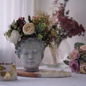 table by the window with interior details antique bust of Venus with flowers instead of hair